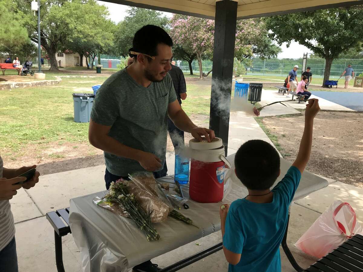 Frank Herkules demonstrates how liquid nitrogen quickly freezes the water on flower petals at the Woodlawn Lake Fourth of July celebration. Herkules said the frozen water causes the petals to change texture and become very fragile.