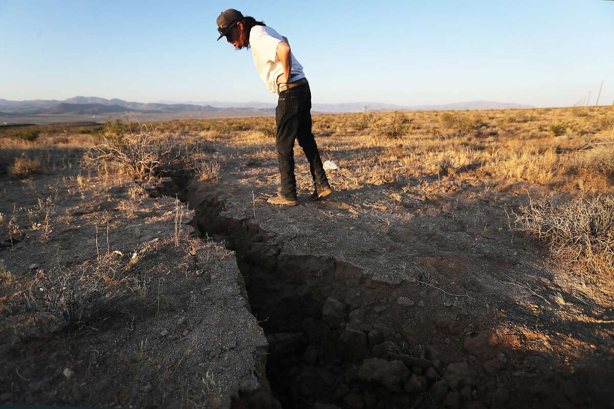 A local resident inspects a crack in the earth after a 6.4 magnitude earthquake struck the area on July 4, 2019 near Ridgecrest.