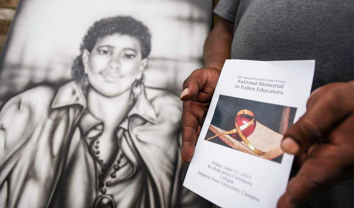 Nataujia and Mark DeJohn Sr. pose while holding a drawing of Mark's late mother Russell Jean DeJohn Hampton and a ceremony booklet from the National Memorial to Fallen Educators at their house in Port Arthur on Tuesday. Hampton was shot and killed in 1988 as she was driving a school bus in Port Arthur. The drawing was given to Mark by his brother Timothy Hampton, who works in a prison in Huntsville, after Hampton himself was given the art by an inmate who signed the drawing as J. Hurd. Photo taken on 07/02/19. Ryan Welch/The Enterprise