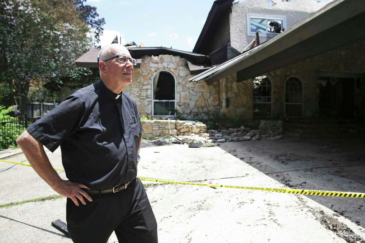 Father Tom Coughlin walks in front of the ruins of the House of Deaf Seminarians in Castle Hills on Friday, explaining the predicament of residents displaced by Tuesday’s fire there.