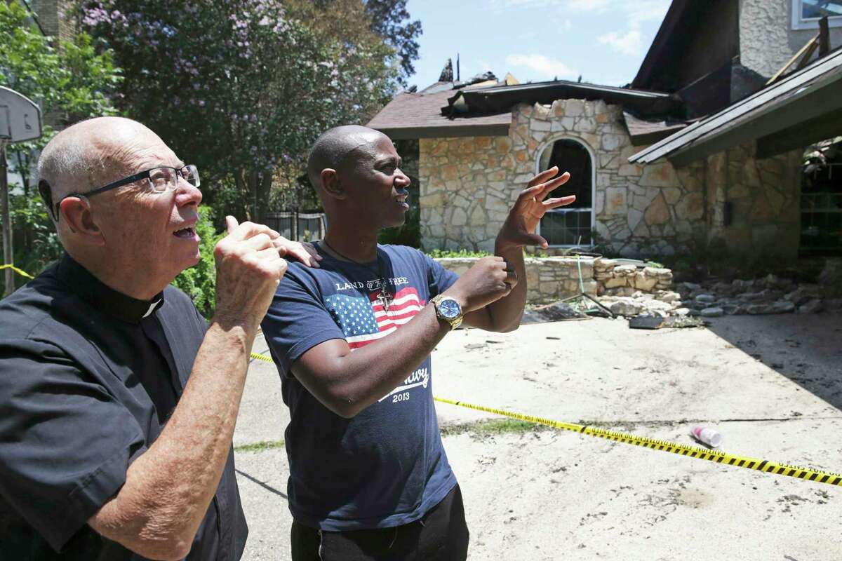 Father Tom Coughlin gets a description of the catastrophe from Brother Alex Mary Nyangezi, explaining the predicament of residents displaced by the fire at the House of Deaf Seminarians in Castle HIlls on July 5, 2019. Father Coughlin uses a hearing aid or sound amplifier that helps him hear some sounds.