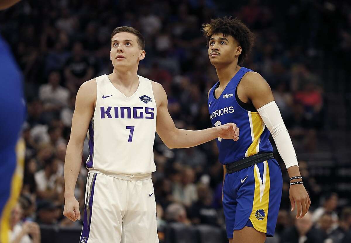 Sacramento Kings guard Kyle Guy, left, and Golden State Warriors guard Jordan Poole, right, stand on the court during the first half of an NBA basketball summer league game in Sacramento, Calif., Monday, July 1, 2019. The Kings won 81-77. (AP Photo/Rich Pedroncelli)