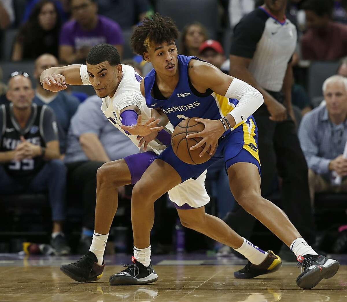 Sacramento Kings guard Justin James, left, tries to steal the ball from Golden State Warriors guard Jordan Poole during the first half of an NBA basketball summer league game in Sacramento, Calif., Monday, July 1, 2019. (AP Photo/Rich Pedroncelli)