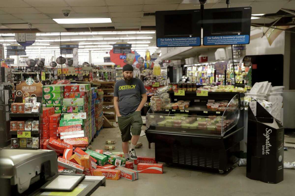 A worker steps over merchandise that is scattered on the floor of a Albertson's grocery store Saturday, July 6, 2019 following a earthquake in Ridgecrest, Calif. The Friday evening quake with a magnitude of about 7.1 jolted much of California, cracking buildings, setting fires, breaking roads and causing several injuries while seismologists warned that large aftershocks were expected to continue for days, if not weeks. ( AP Photo/Marcio Jose Sanchez)