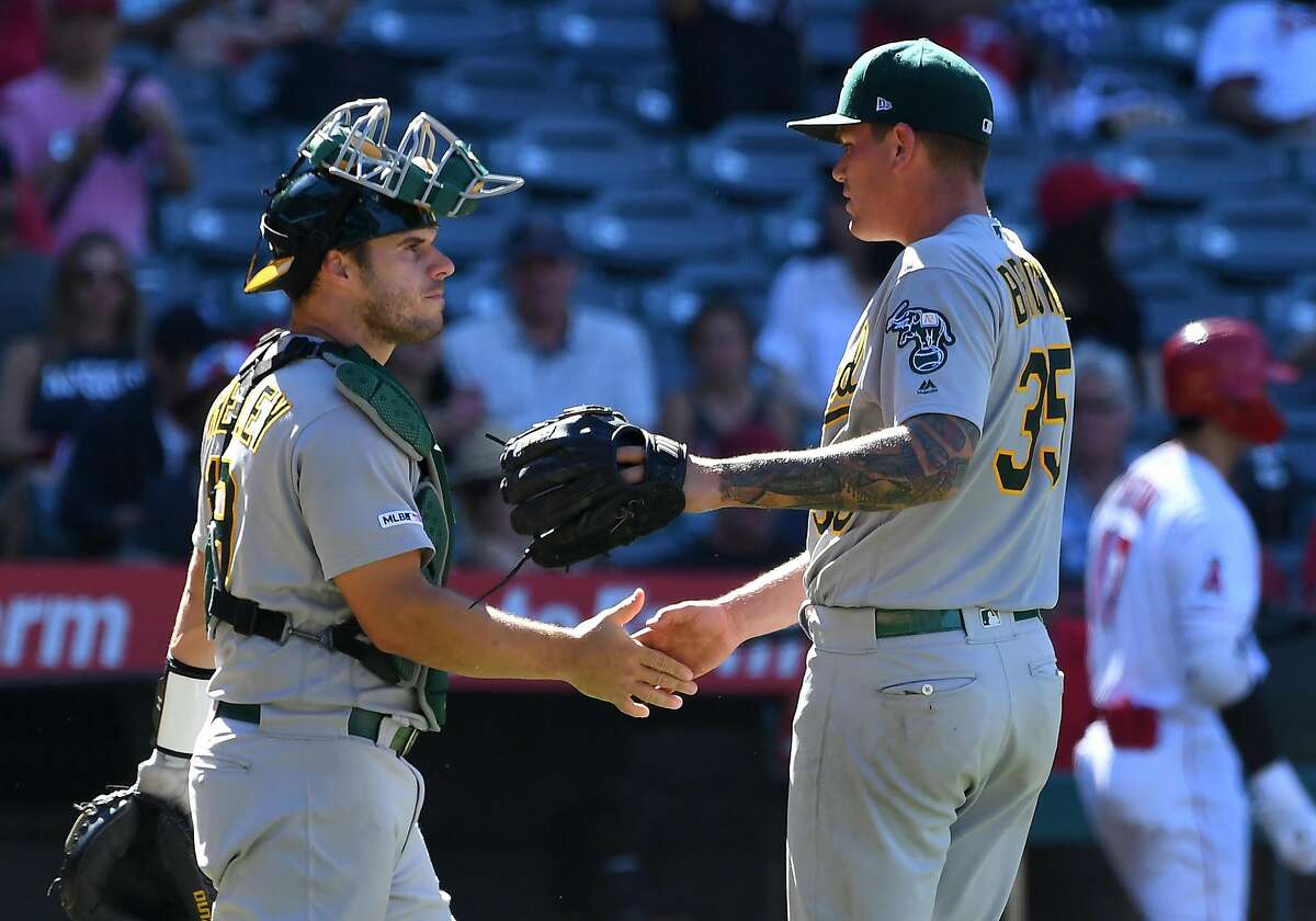 ANAHEIM, CA - JUNE 30: Relief pitcher Aaron Brooks #35 gets a hand shake from Josh Phegley #19 of the Oakland Athletics after the final out of the ninth inning of the game against the Los Angeles Angels at Angel Stadium of Anaheim on June 30, 2019 in Anaheim, California. (Photo by Jayne Kamin-Oncea/Getty Images)