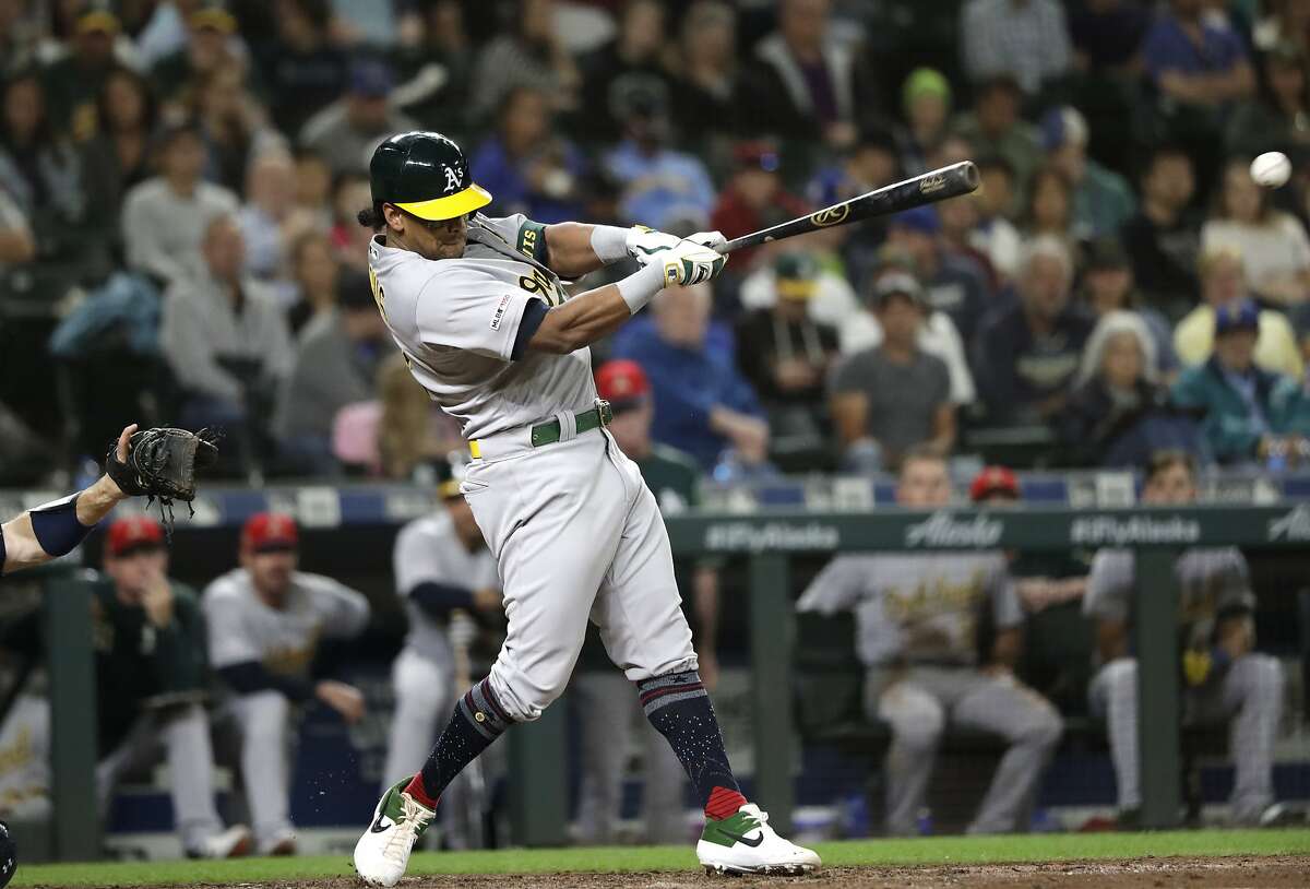 Oakland Athletics' Khris Davis drives in a run on a single against the Seattle Mariners in the seventh inning of a baseball game Friday, July 5, 2019, in Seattle. (AP Photo/Elaine Thompson)