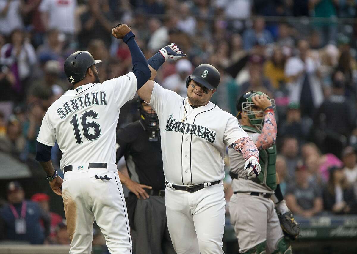 Seattle Mariners' Domingo Santana (16) greets Daniel Vogelbach after Vogelbach's two-run home run during the fourth inning in a baseball game against the Oakland Athletics on Saturday, July 6, 2019, in Seattle. (AP Photo/Lindsey Wasson)