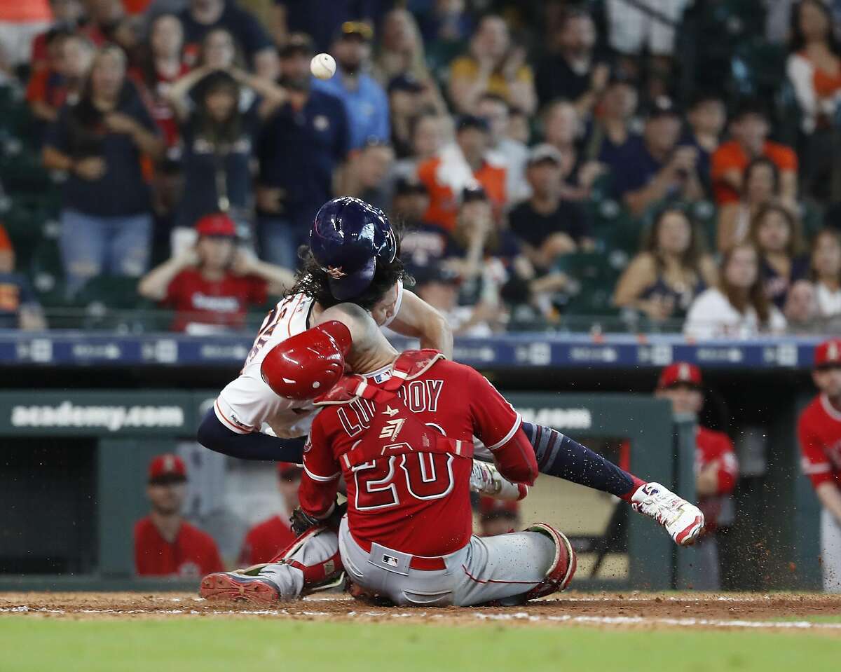 Los Angeles Angels catcher Jonathan Lucroy (20) and Astros runner Jake Marisnick collide at home during the eighth inning Sunday at Minute Maid Park. Marisnick was called out on the play