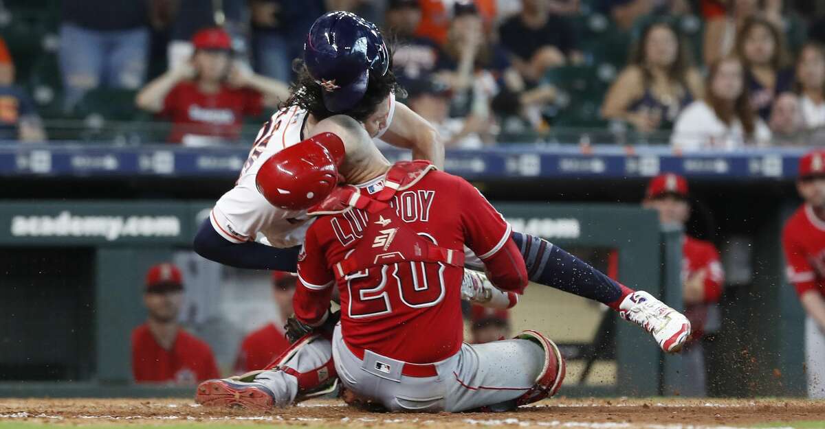 Los Angeles Angels catcher Jonathan Lucroy (20) and Houston Astros Jake Marisnick (6) collide at home during the eighth inning of an MLB game at Minute Maid Park, Sunday, July 7, 2019, in Houston.
