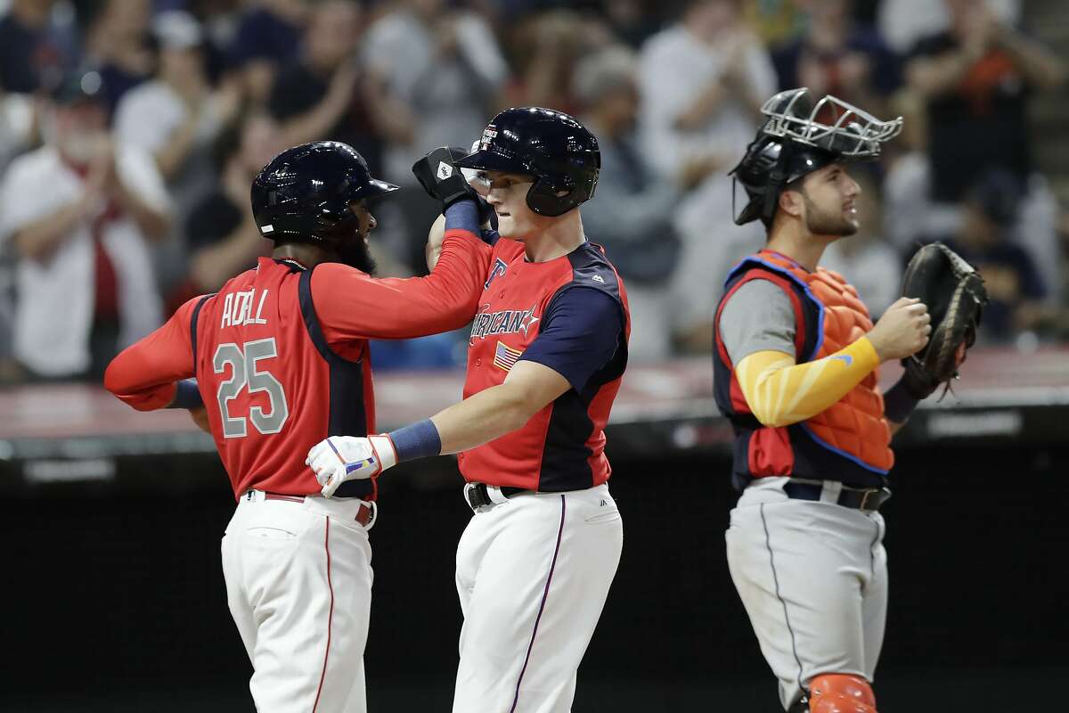 Sam Huff, center, of the Texas Rangers, and Jo Adell, of the Los Angels Angels, celebrate after Huff hit a two-run home run during the seventh inning of the MLB All-Star Futures baseball game, Sunday, July 7, 2019, in Cleveland. The MLB baseball All-Star Game is to be played Tuesday. Joey Bart, of the San Francisco Giants, is at right. (AP Photo/Tony Dejak)