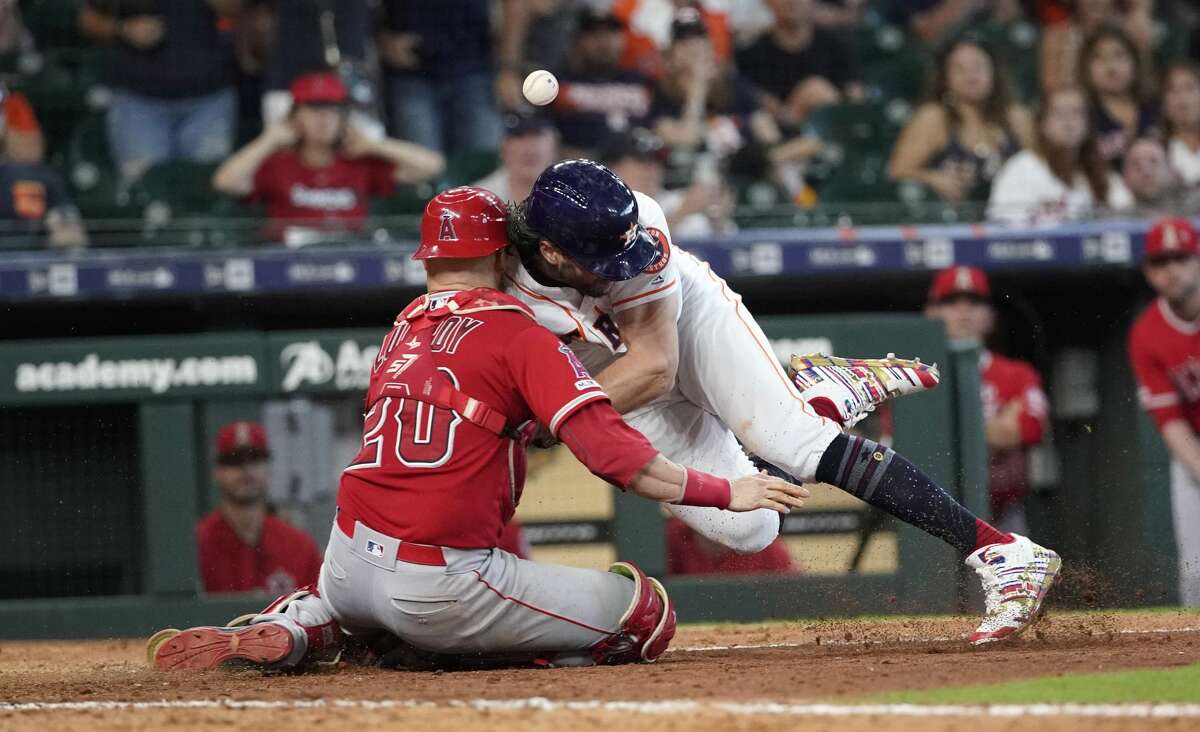 Houston Astros' Jake Marisnick, right, collides Los Angeles Angels catcher Jonathan Lucroy (20) while trying to score during the eighth inning of a baseball game Sunday, July 7, 2019, in Houston. Marisnick was called out under the home plate collision rule.