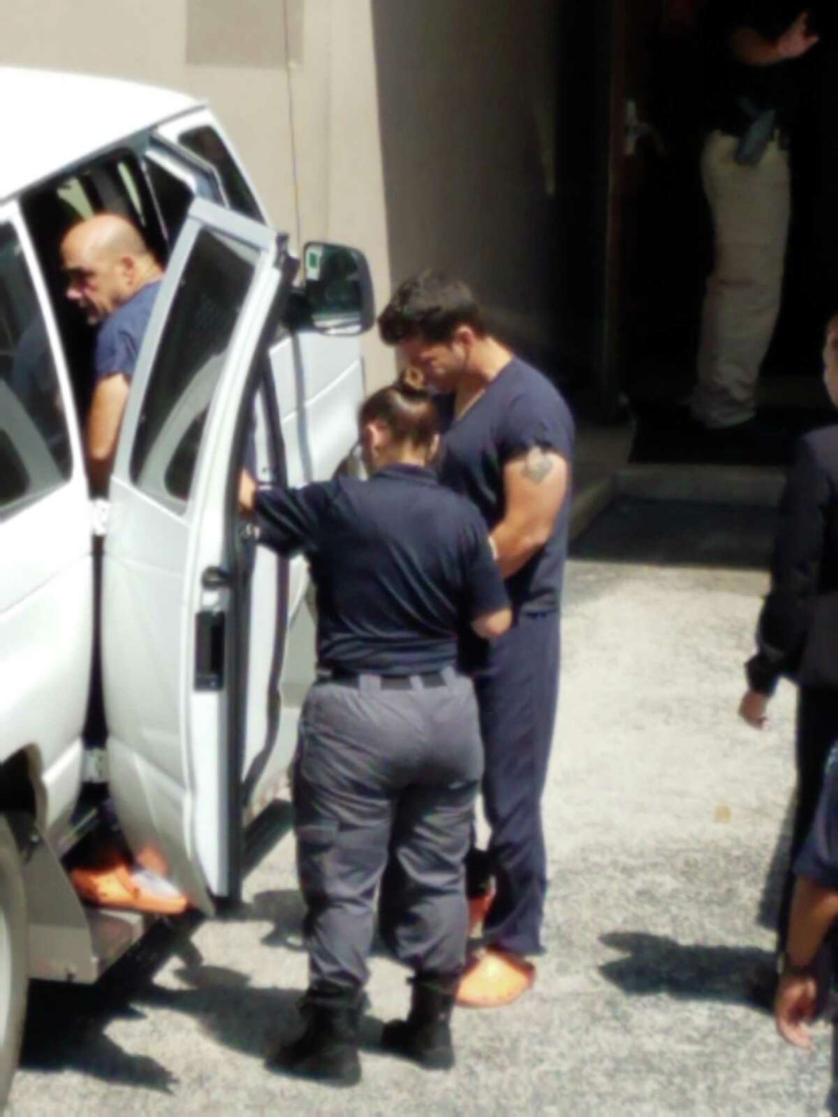 Marino Maury Diaz-Leon, 52, gets into a vehicle to be taken back to jail after a hearing in federal court in San Antonio on Monday, July 8, 2019. Behind him is co-defendant  Fernando Guardado Vazquez, 40. The two men are accused of bribing a state employee to sidestep rules requiring trucking safety tests before a commercial driver's license is issued.