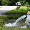Water from a fire hydrant flows toward Little Caney Creek after a pump failure from a Conroe sewage collection facility along South Loop 336 East on July 8 caused an estimated one million gallons to overflow from the sewer.