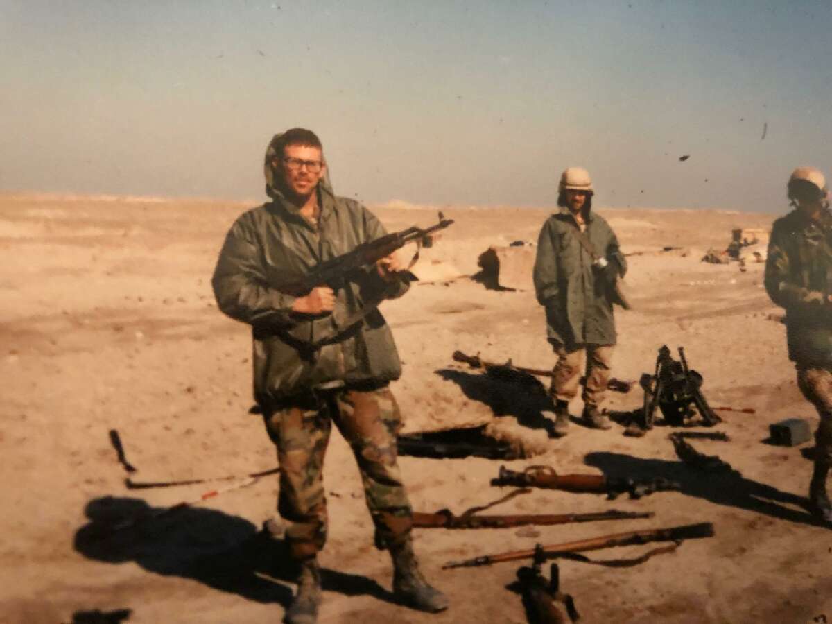 Scene from the Gulf War: Mike Glenn and a couple of his troops in Iraq. Glenn holds an AK-47 assault rifle confiscated from a prisoner.