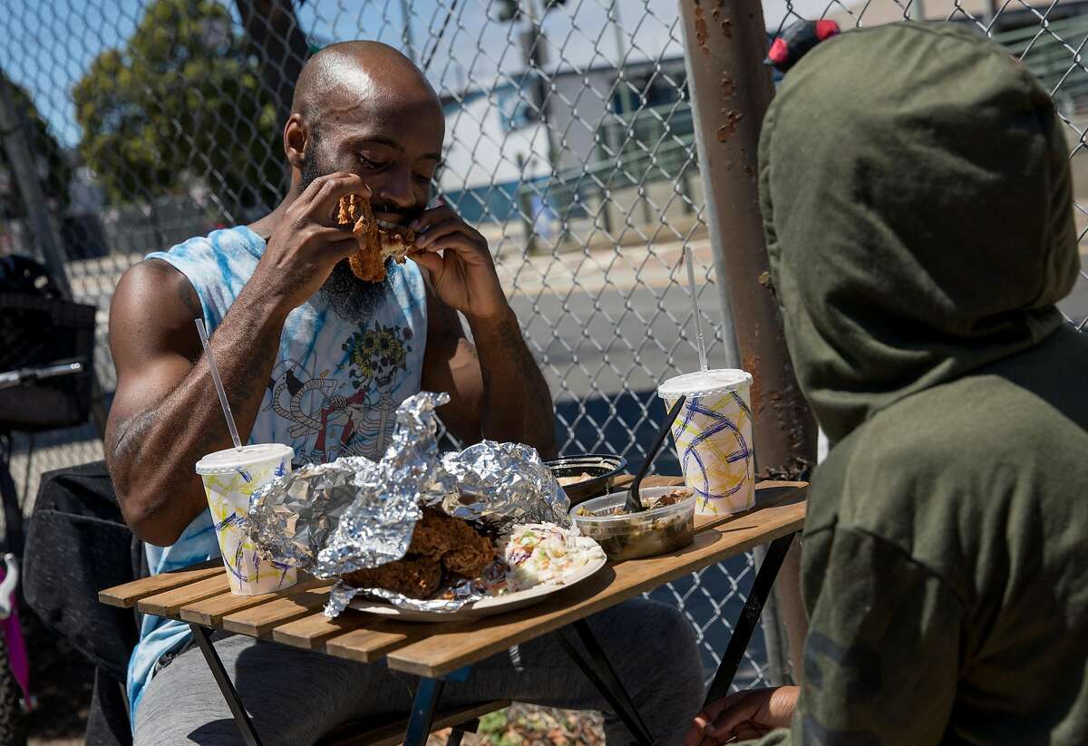 Maurice Hightower of San Francisco eats lunch from Soul Bowl'z with his daughter Imani Hightower, 12, at the Bayview Bistro food truck park in the Bayview district of San Francisco, Calif. Wednesday, July 10, 2019.