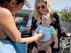 A friend greets Stephanie Lee as she holds her son Colin, 10 months, while watching her daughter Campbell's swim lesson at the Rancho San Miguel Swim Club in Walnut Creek, Calif. Tuesday, July 9, 2019.