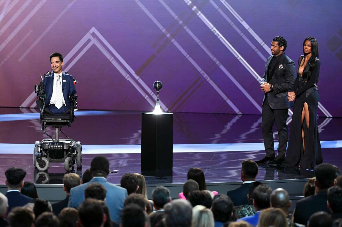 (Left to right) Rob Mendez accepts the Jimmy V Award For Perseverance as Russell Wilson and Ciara listen onstage during The 2019 ESPYs at Microsoft Theater on July 10, 2019 in Los Angeles, California.