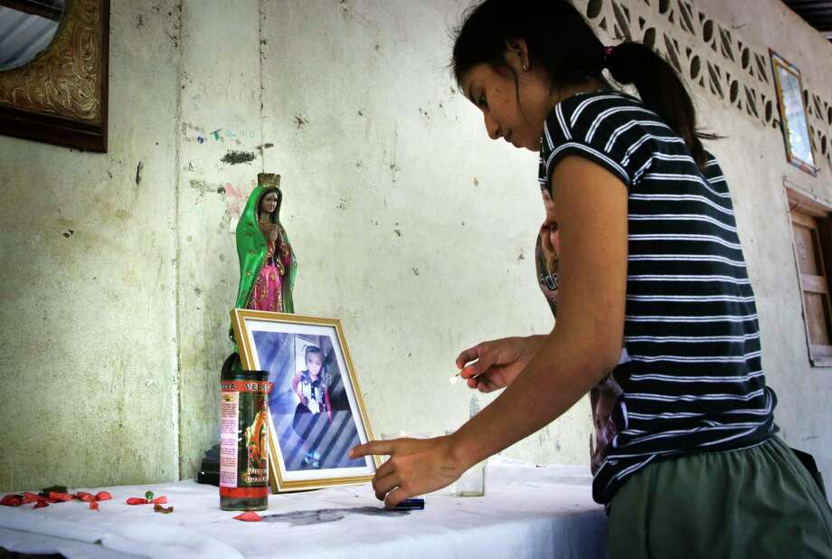 Vivian Aguilar, 20, aunt of Juana Anastasia, 3, from Valle Lirio, Guatemala, lights a candle at a small shrine for the toddler. / ©2019 San Antonio Express-News