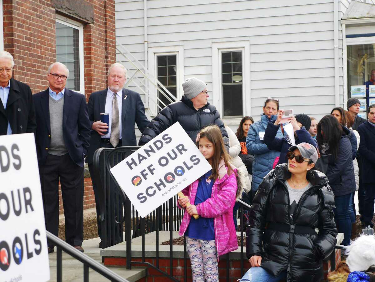 Members of Hands Off Our Schools protest in Ridgefield, in February, in opposition to bills proposed in the Connecticut legislature that would have forced schools to reginoalize.