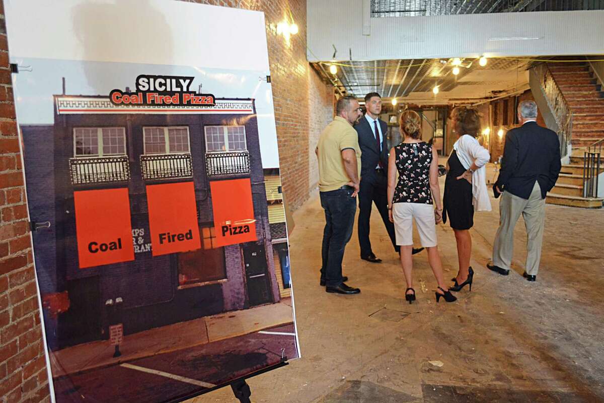 Wallingford developer Dominick DeMartino, far left, in yellow, announced Thursday his purchase of the R. W. Camp’s building at 412 Main St., which he’ll be turning into Sicily, a coal-fired pizza restaurant with a family atmosphere, which will include two bars, a dining room and lounge downstairs.