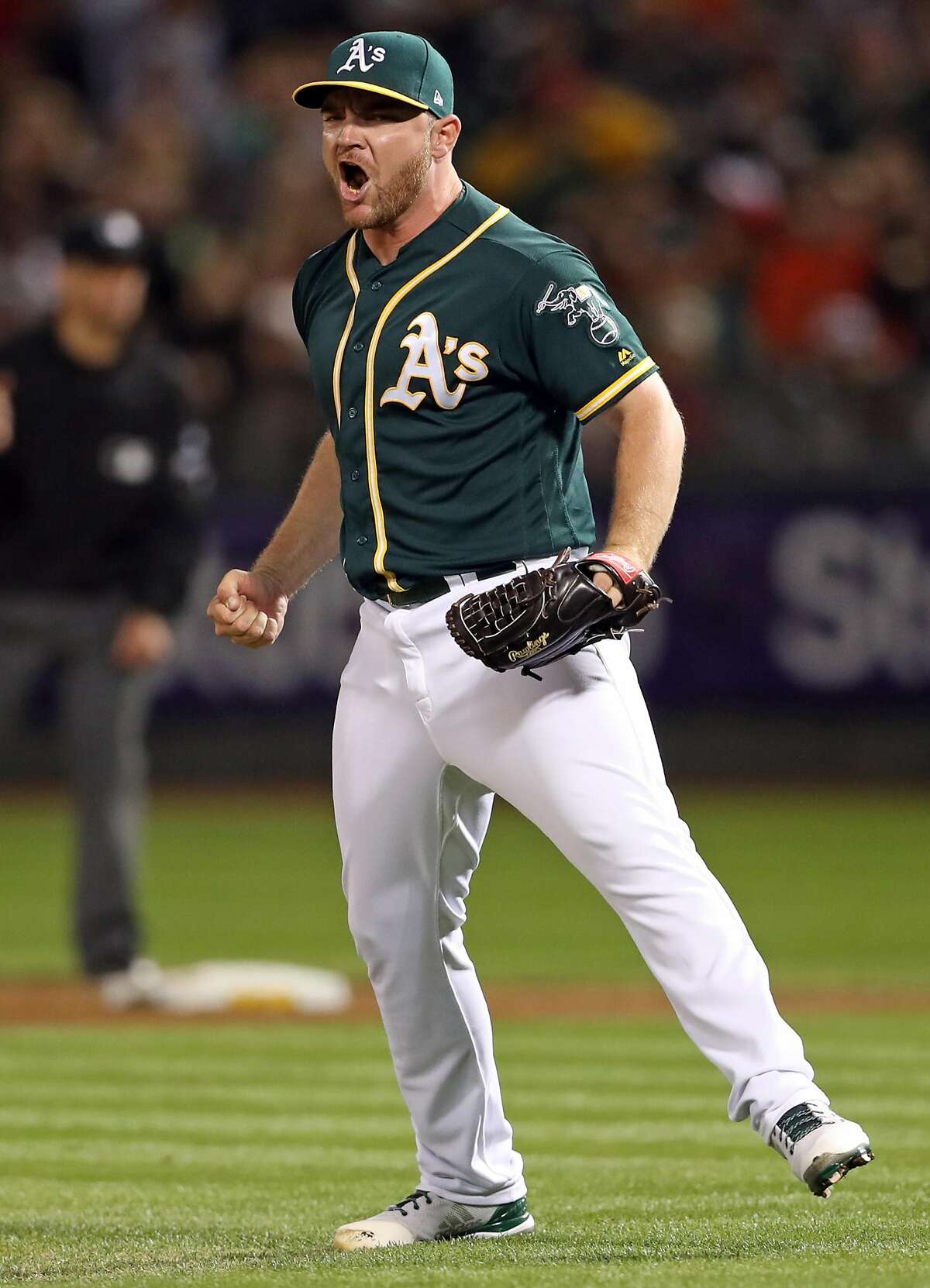 Oakland Athletics' Liam Hendriks reacts to striking out San Francisco Giants' Buster Posey with the tying run on 3rd base to end top of 7th inning during MLB game at Oakland Coliseum in Oakland, Calif. on Monday, July 31, 2017.
