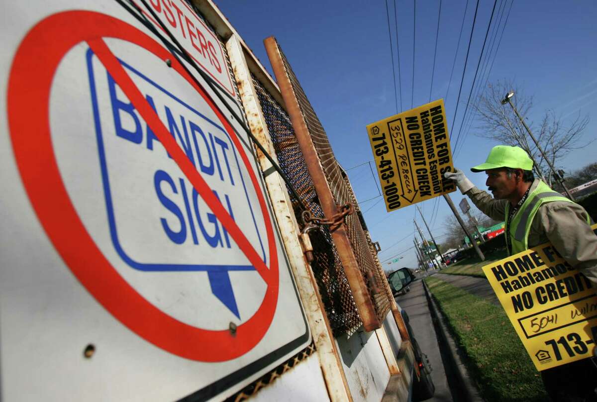 Nicolas Cortez (cq), a city of Houston Public Works employee collects bandit signs along Reed Road on Wednesday January 9, 2008 in Houston. City workers routinely collect the signs from publicly owned sections. (Chronicle) Sharon Steinmann