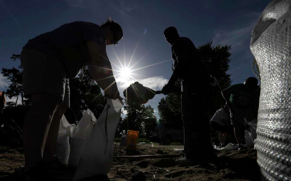 Residents fill sandbags Friday, July 12, 2019, in Baton Rouge, La., ahead of Tropical Storm Barry. The National Weather Service in New Orleans says water is already starting to cover some low lying roads in coastal Louisiana as Barry approaches the state from the Gulf of Mexico. (AP Photo/David J. Phillip)