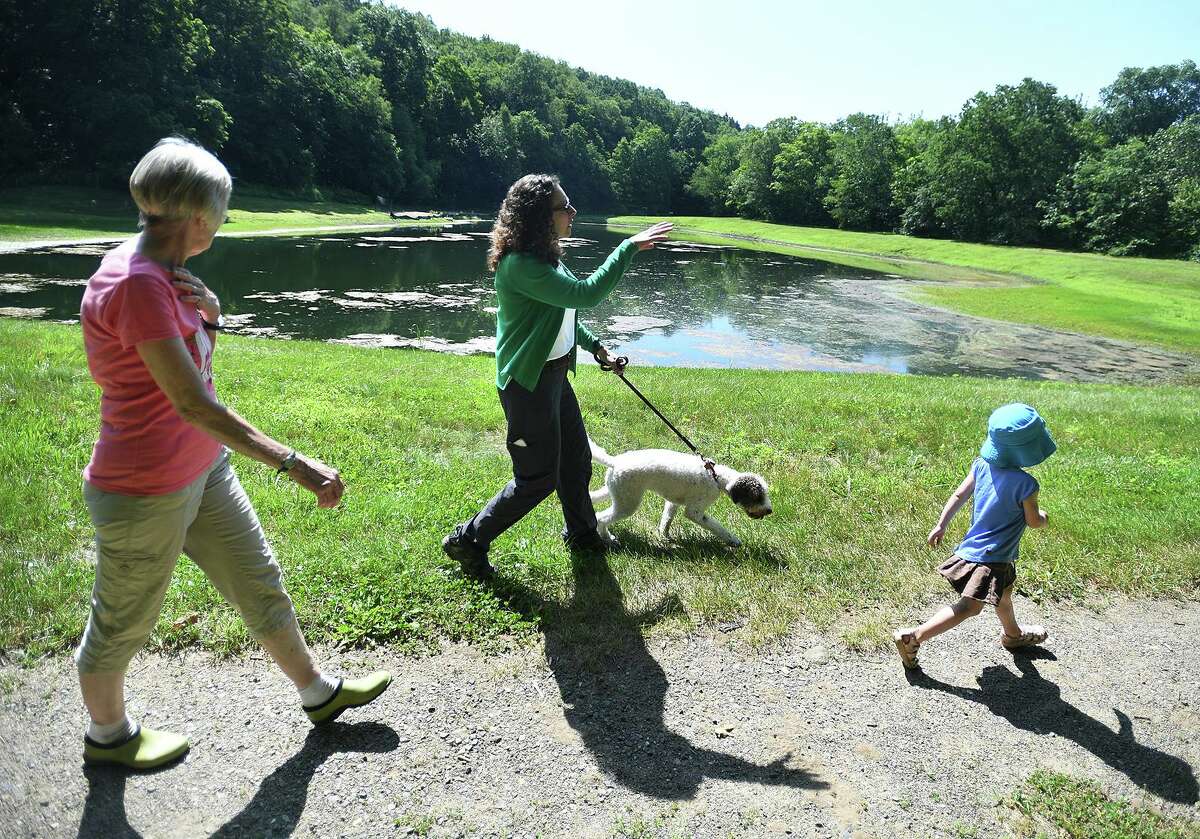 Roxbury Land Trust Executive Director Ann Astarita, center, leads a hike to the Shepaug River with Jeri Hollister, left, and Fiona Steinnagel, 3, both of Bridgewater, during a trust program for pre-K and kindergarteners at the River Road Preserve in Roxbury, Conn. on Tuesday, July 9, 2019. The program runs each Tuesday morning for the month of July with visits to different trust properties.