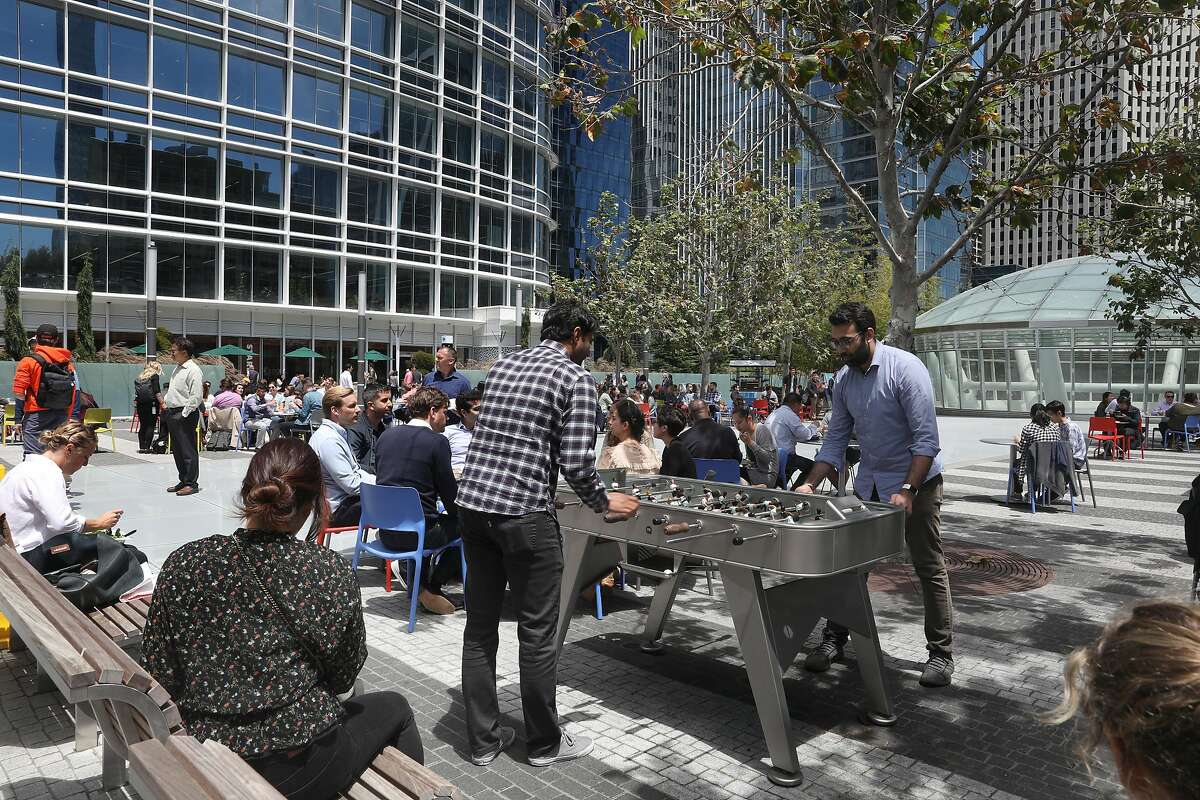 Sherry Siddiqi (middle left)) and Deloitte Prateek Malik (right) take a break for lunch at Salesforce Park playing foosball on Thursday, July 11, 2019 in San Francisco, Calif.