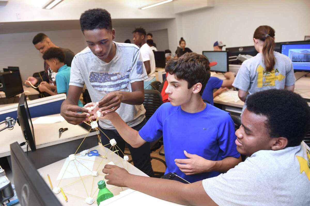 From left, Micah Bacote, 13, Christopher Hergott, 14, and Landon Harris, 14, of the Hamden Engineering Career Academy create a structure with sticks and marshmallows during a civil engineering exercise at Gateway Community College New Haven Friday. After they are completed the models are put on a shake plate to test their effectiveness to withstand earthquakes.