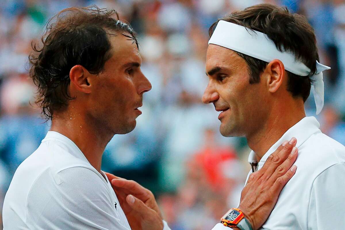 TOPSHOT - Switzerland's Roger Federer (R) shakes hands and embraces Spain's Rafael Nadal (L) after Federer won their men's singles semi-final match on day 11 of the 2019 Wimbledon Championships at The All England Lawn Tennis Club in Wimbledon, southwest London, on July 12, 2019. (Photo by Adrian DENNIS / POOL / AFP) / RESTRICTED TO EDITORIAL USEADRIAN DENNIS/AFP/Getty Images