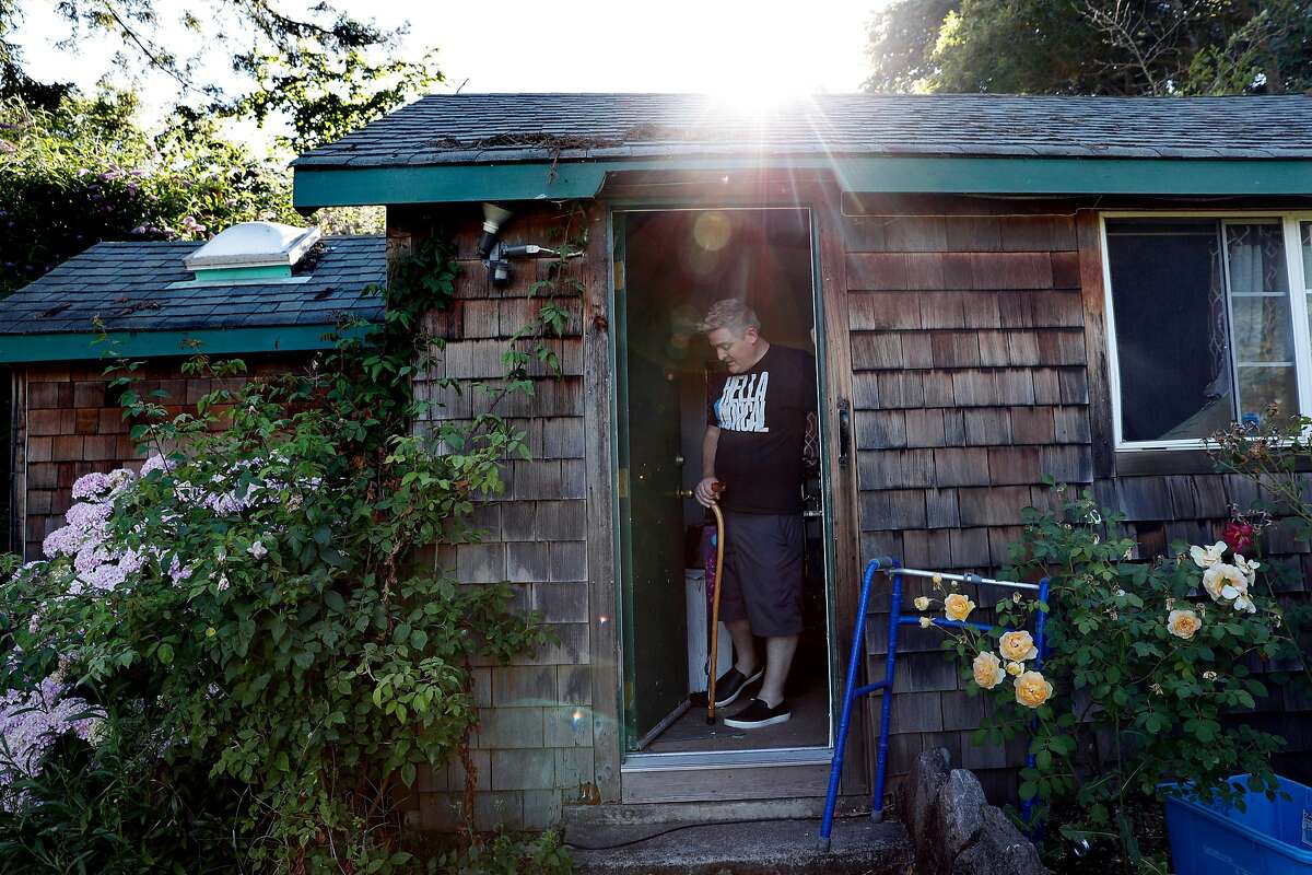 Glenn Sauber transfers to a walker to go back to his house from his band practice room at his home in Sebastopol, Calif., on Wednesday, July 10, 2019.  