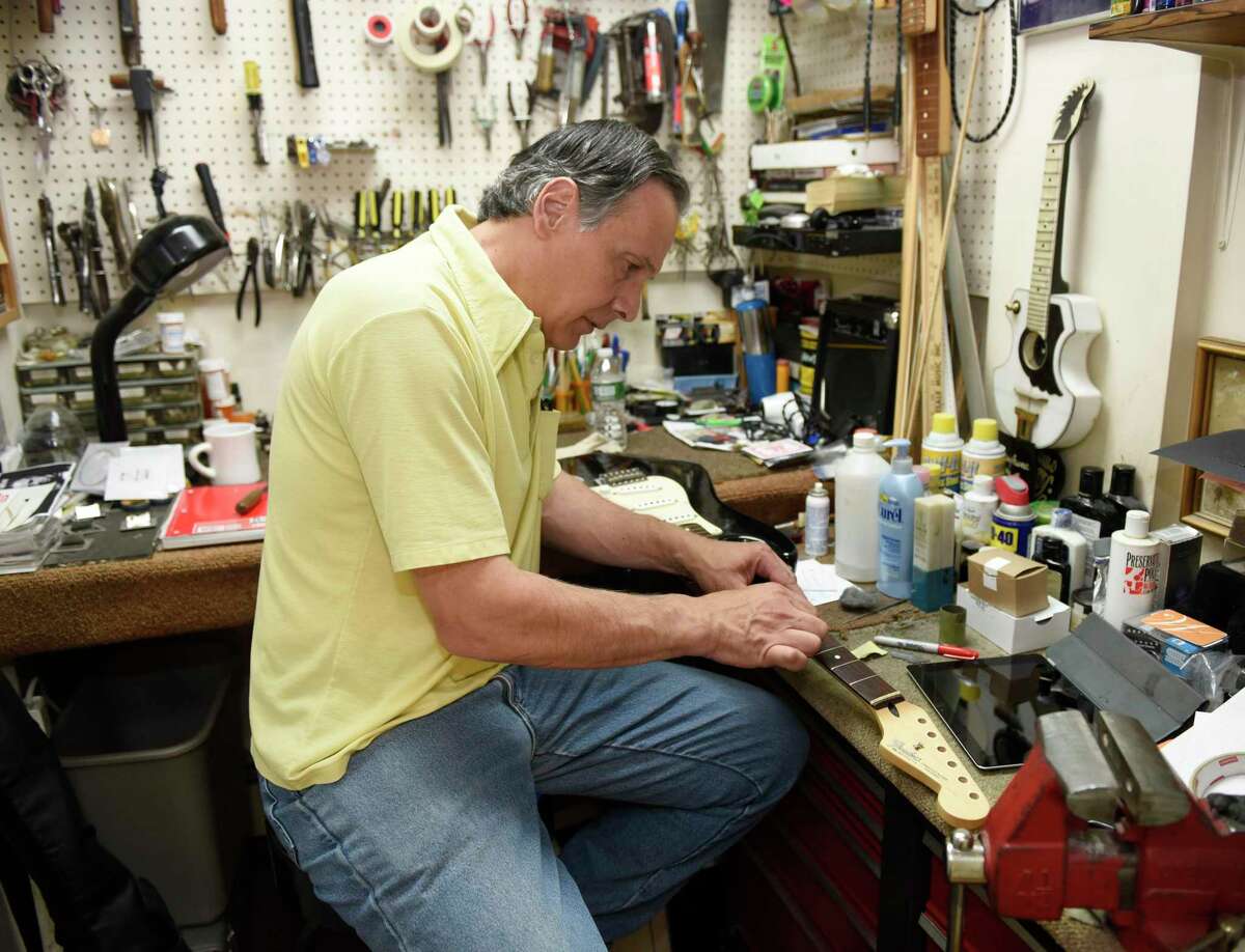 Store owner Joe Roberts repairs a guitar at Connecticut Music in Stamford, Conn. Thursday, July 11, 2019. Roberts' brother, Mike, passed away on New Years Eve and Joe has been running the business by himself since then. After 70 years in business, the store will close its doors this month, but Roberts will still be available for instrument repairs out of his home.