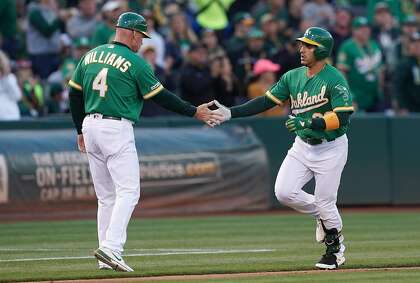 OAKLAND, CA - JULY 12: Ramon Laureano #22 of the Oakland Athletics is congratulated by third base coach Matt Williams #4 after Laureano hit a solo home run against the Chicago White Sox in the bottom of the second inning at Ring Central Coliseum on July 12, 2019 in Oakland, California. (Photo by Thearon W. Henderson/Getty Images)