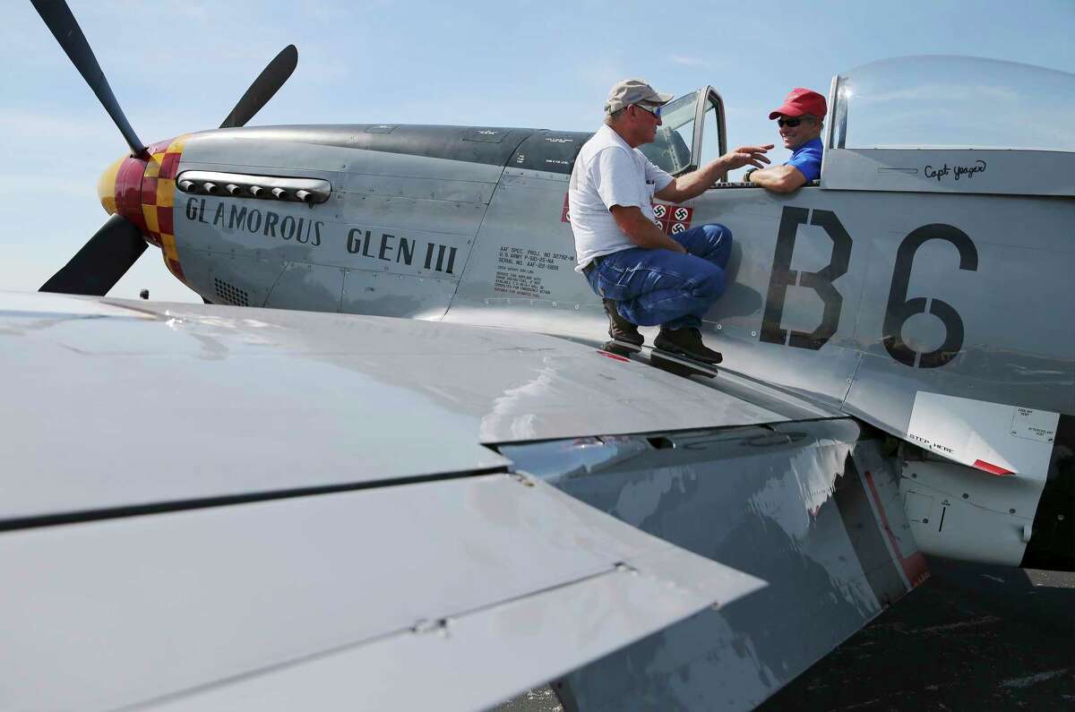 P-51 Pilot and owner James Bohannon, Jr. (left) lets Jeff Purkiss of Bulverde sit in the cockpit while telling stories of the plane's historical past as the "Tex" Hill Wing of the Commemorative Air Force at Stinson Municipal Airport celebrates the birthday of World War II fighter ace David Lee "Tex" Hill with sorties of vintage aircraft, hot rods on display and demonstrations of WWII weapons on Saturday, July 13, 2019. Guests made their way around a field of aircrafts such as P-51 Mustangs along with World War II military history exhibits dotting the tarmac. Some guests took to the air with flights in a T-34 Air Force trainer or the CAF's own T-6 Texan aircraft named, Ole Yeller. Hill, who died in 2007, was a member of the legendary Flying Tigers who flew combat missions in the Chinese-Burma-India theater of WWII against Japanese forces. The CAF was founded to educate people about American military aviation and aircraft through preservation and restoration and shows. (Kin Man Hui/San Antonio Express-News)