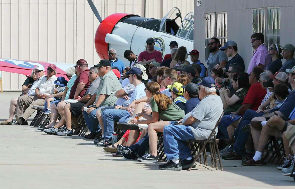 Spectators gather to hear a lecture from members of the National Museum of the Pacific War as the "Tex" Hill Wing of the Commemorative Air Force at Stinson Municipal Airport celebrates the birthday of World War II fighter ace David Lee "Tex" Hill with sorties of vintage aircraft, hot rods on display and demonstrations of WWII weapons on Saturday, July 13, 2019.