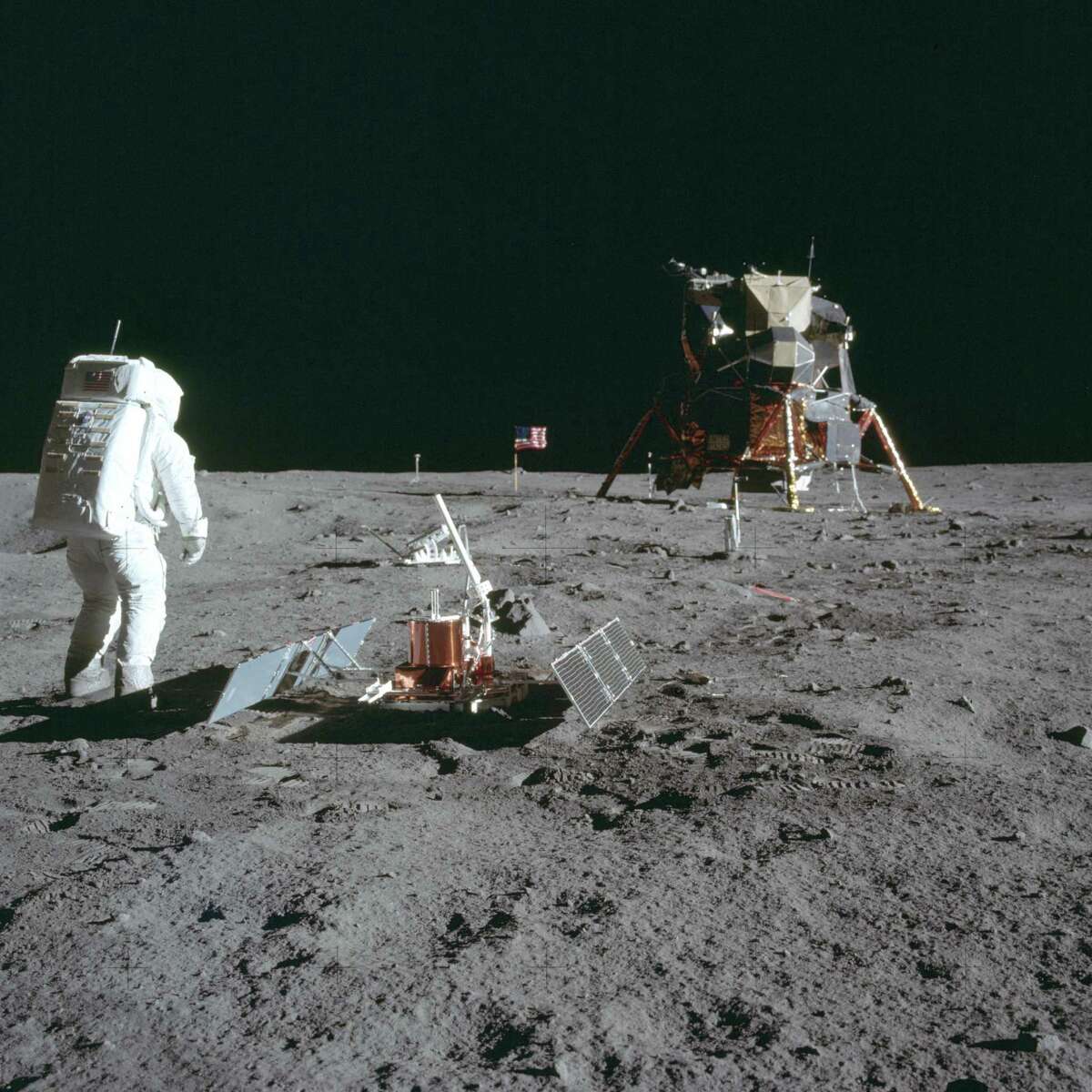 In this July 20, 1969 photo made available by NASA, astronaut Buzz Aldrin Jr. stands next to the Passive Seismic Experiment device on the surface of the the moon during the Apollo 11 mission.