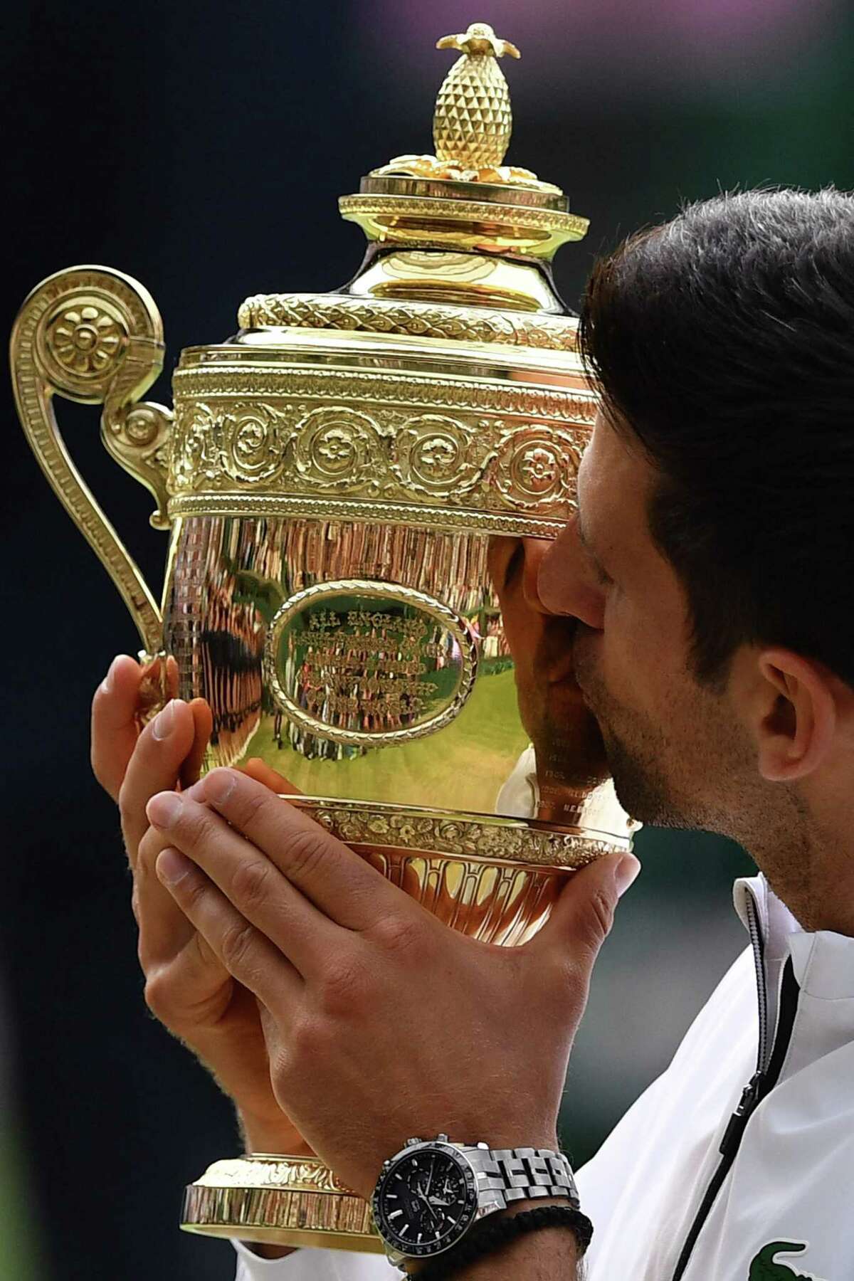 Serbia's Novak Djokovic kisses the winner's trophy after beating Switzerland's Roger Federer during their men's singles final on day thirteen of the 2019 Wimbledon Championships at The All England Lawn Tennis Club in Wimbledon, southwest London, on July 14, 2019. (Photo by Daniel LEAL-OLIVAS / AFP) / RESTRICTED TO EDITORIAL USEDANIEL LEAL-OLIVAS/AFP/Getty Images