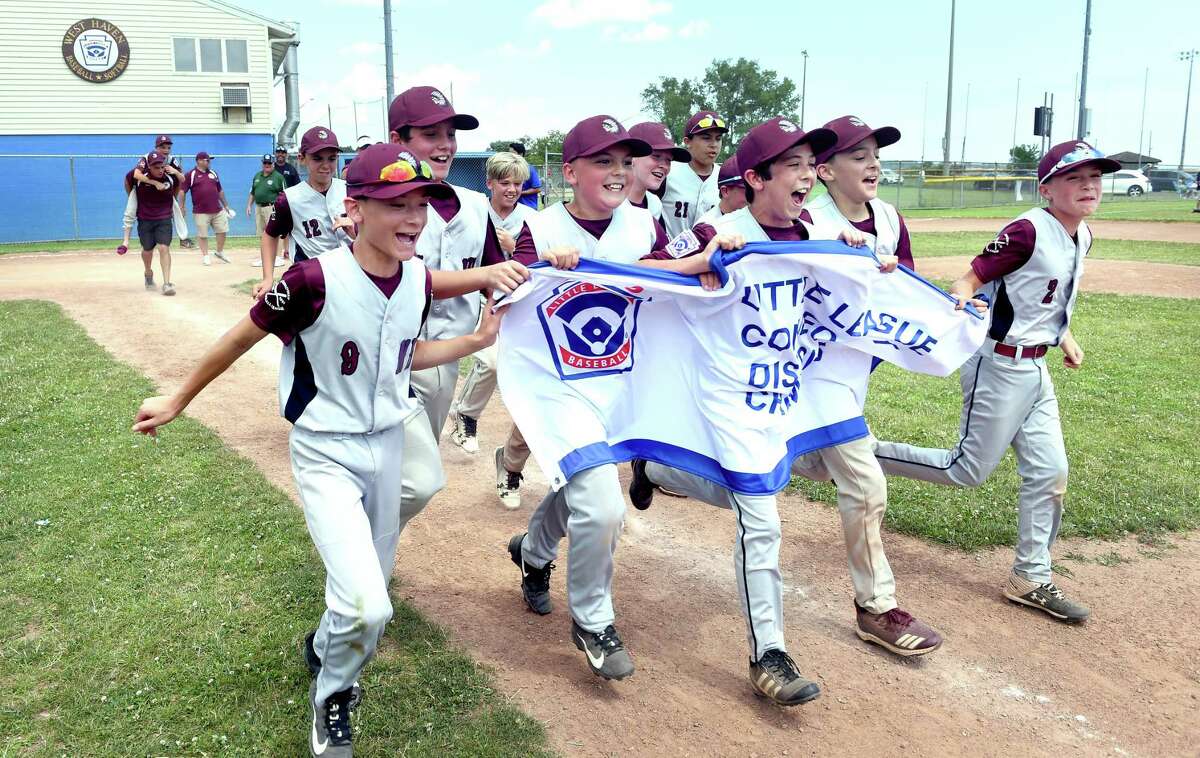 Members of the North Haven Little League team celebrate after defeating Milford to win the District 4 championship in West Haven on Sunday.