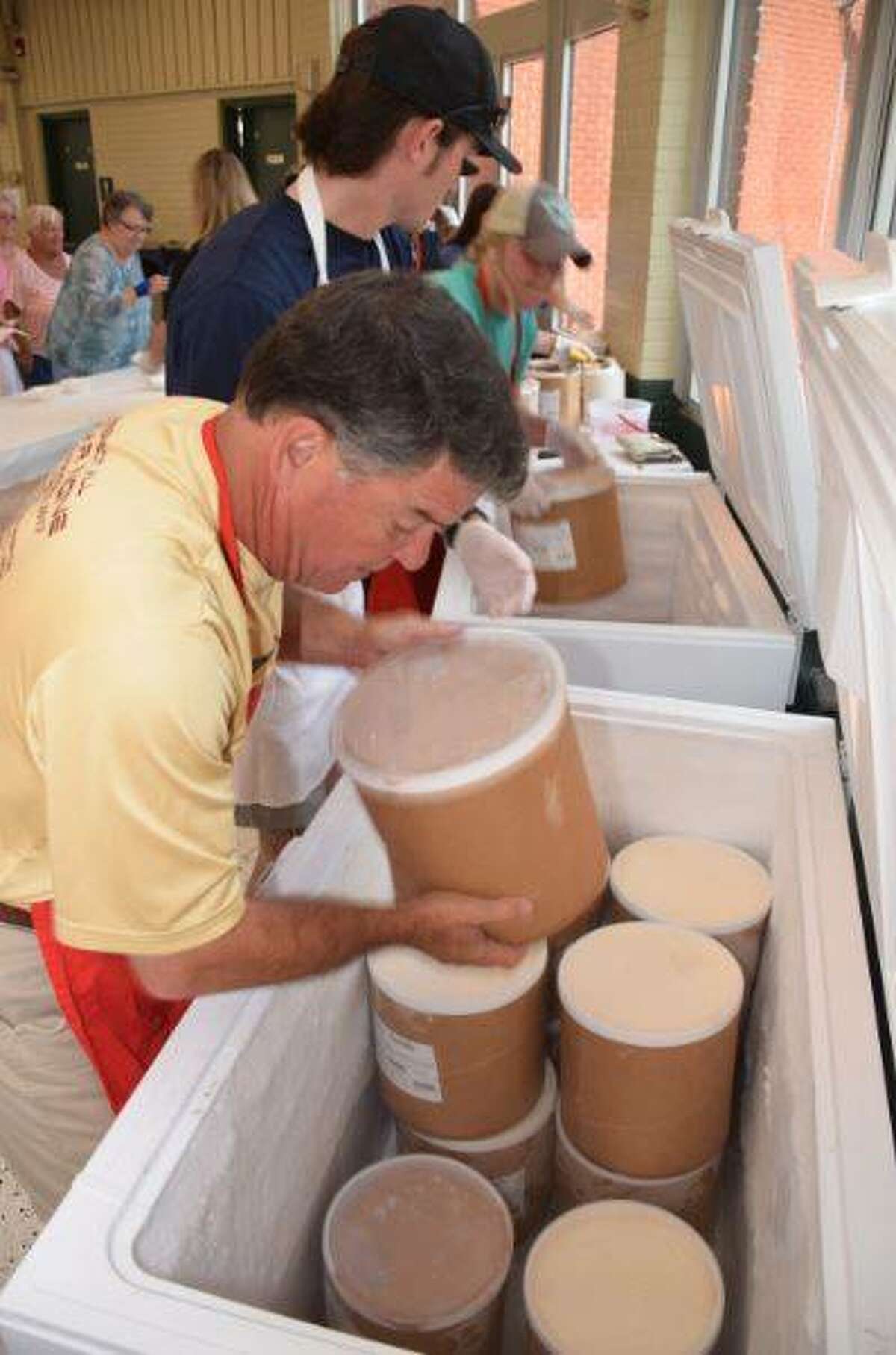 Volunteers pull more ice cream from the freezer to serve Wood River Ice Cream Social visitors on Sunday.