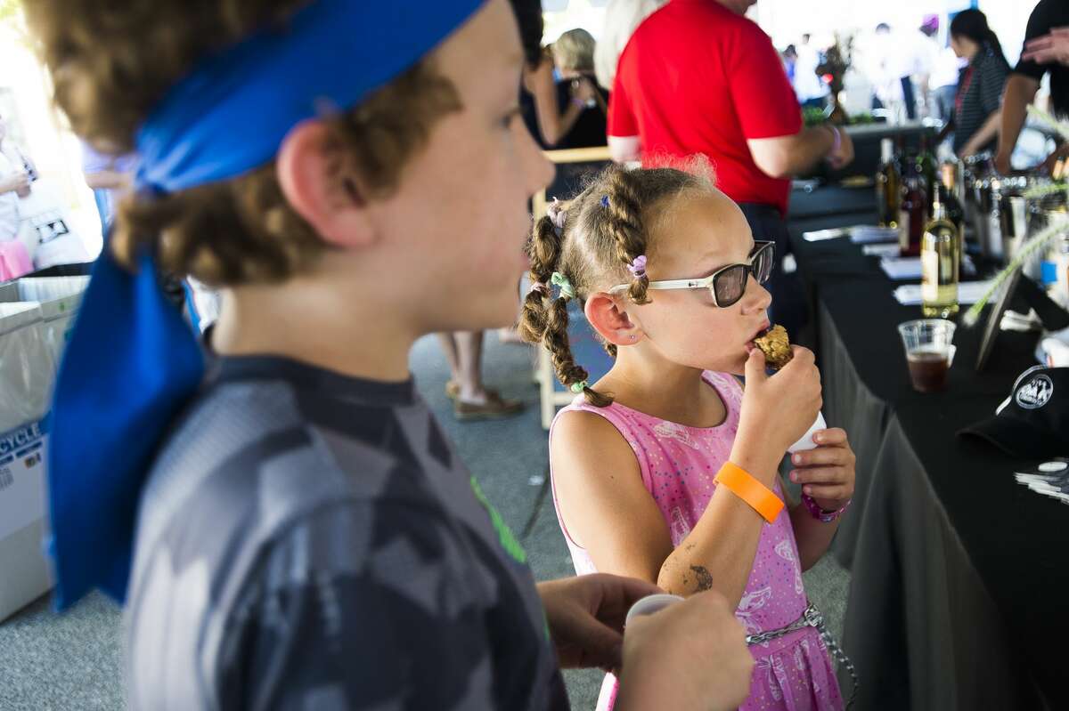Midland residents Eva Lee, 7, right, and Kingston Lee, 10, left, sample food from Live Oak Coffeehouse during the Eat Great Food Festival on Sunday, July 14, 2019 in downtown Midland. (Katy Kildee/kkildee@mdn.net)