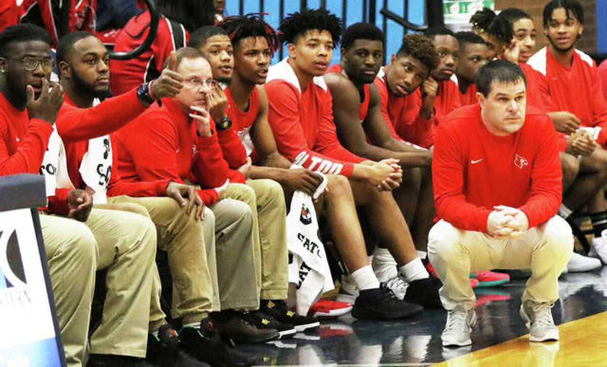 Alton coach Eric Smith (right) watches action from in front of the Redbirds bench during a game last season at Belleville East. Smith, after his final season with the Redbirds, is the 2018-19 Telegraph Large-Schools Boys Basketball Coach of the Year.