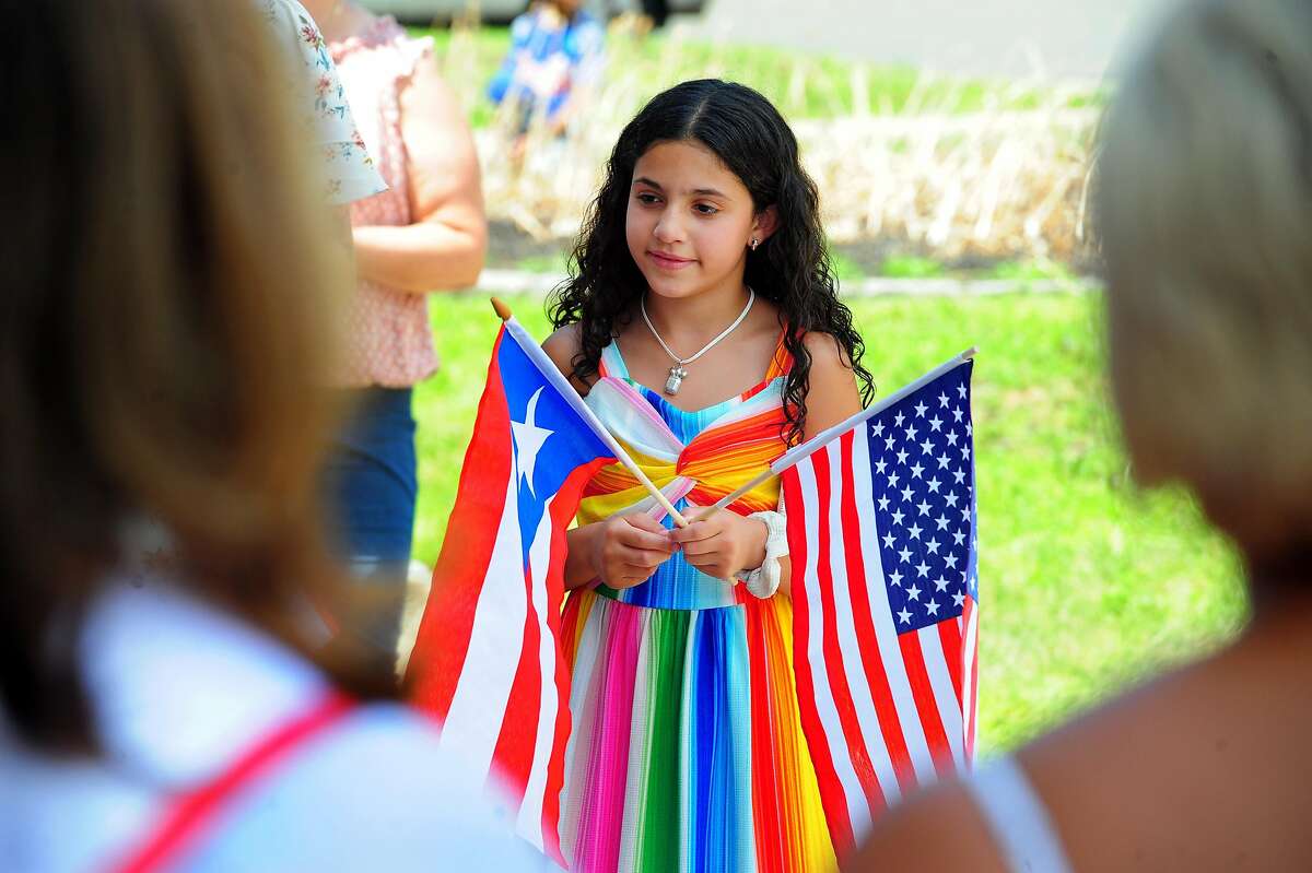 Juiliana Spinelli, 9, holds Puerto Rican and American flags during a Puerto Rican Flag raising ceremony at Bridgeport City Hall in Bridgeport, Conn., on Saturday July 13, 2019. The Peurto Rican Parade of Fairfield County takes place Sunday, beginning at 11 a.m. at Central High School and concludes with an all day celebration at Seaside Park.