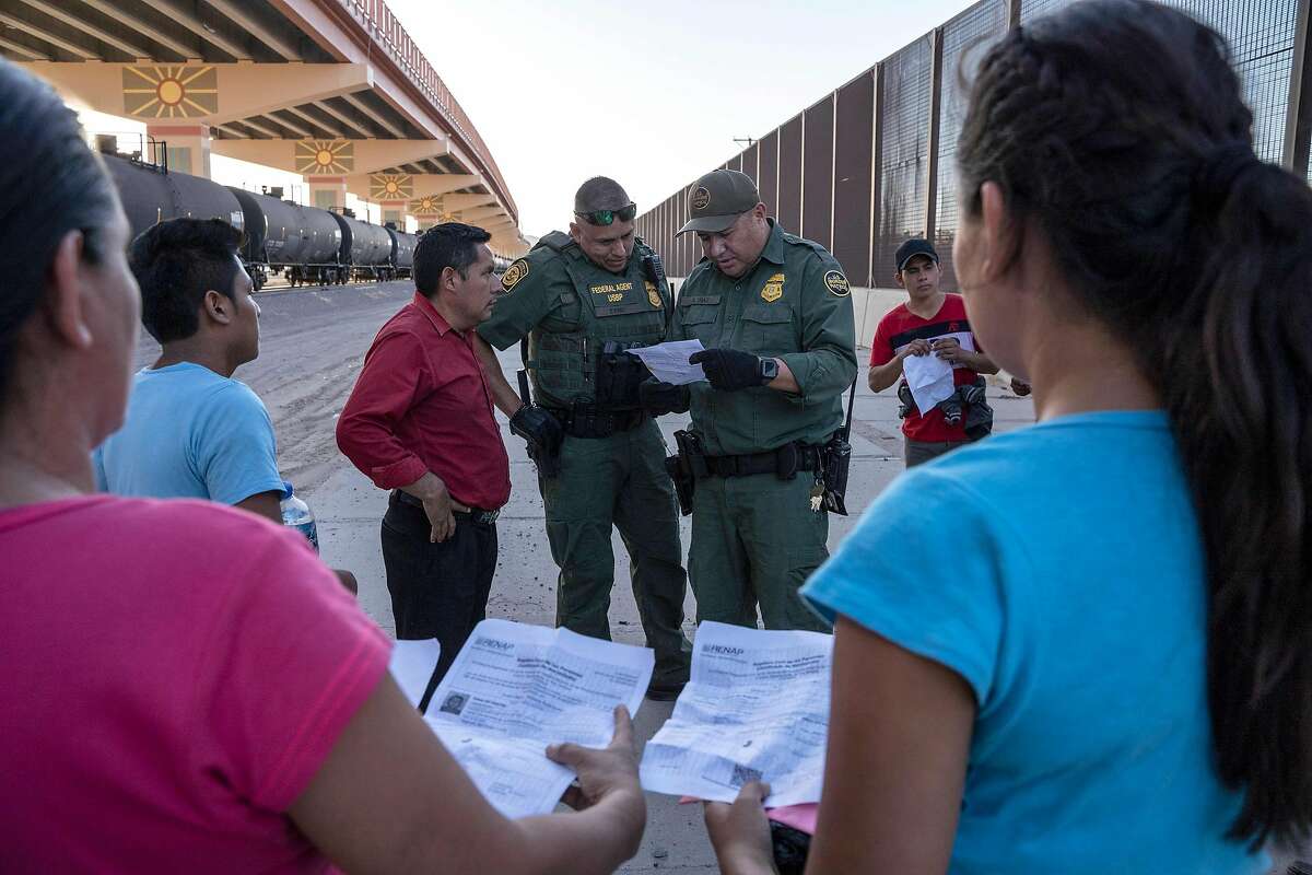 (FILES) In this file photo taken on May 16, 2019 US Customs and Border Protection agents check documents of a small group of migrants, who crossed the Rio Grande from Juarez, Mexico in El Paso, Texas. - The Trump administration moved on July 15, 2019 to block most migrants who cross the US southern border after passing through Mexico from seeking asylum.A new rule redefining asylum eligibility -- to take effect on Tuesday -- is the latest attempt to stem the flow of undocumented migrants into the country, and comes amid White House frustration at Congress's failure to change asylum laws. (Photo by Paul Ratje / AFP)PAUL RATJE/AFP/Getty Images