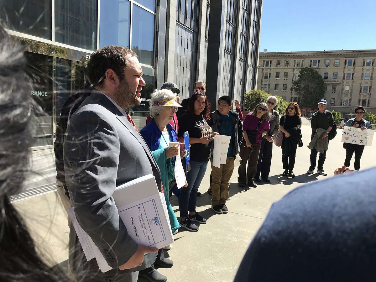 Jordan Wells, an attorney with ACLU Southern California, speaks to a circle of supporters on Monday outside the Philip Burton Federal Building in San Francisco, Calif. Wells represents Jose Bello, a Bakersfield activist detained by ICE two days after performing a poem criticizing immigration policies.