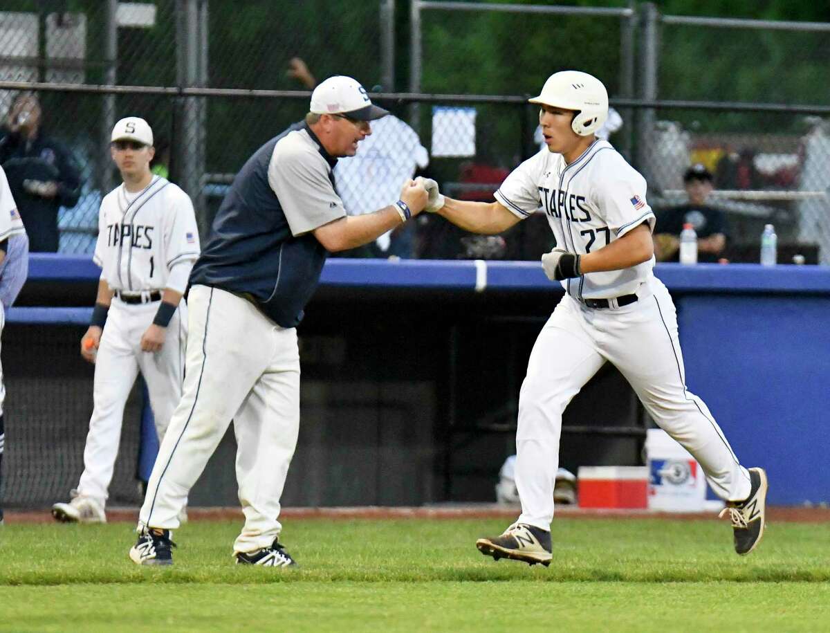 Staples’ Chad Knight fist pumps with coach Jack McFarland following his first inning solo home run against Danbury in the FCIAC baseball semifinalsat Cubeta Stadium in Stamford on May 23, 2017.