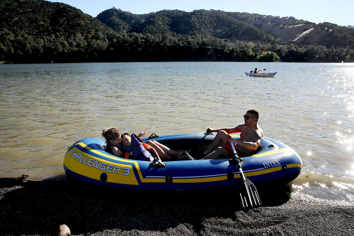 Maribel Cabrera, 31, holds Nicholas Allred, 8, the nephew of her boyfriend, David Wong, 29, as they prepare to boat in Lake del Valle at Del Valle Regional Park in Livermore, Calif., on Saturday, July 13, 2019. Rising temperatures are expected to make parts of the nation unlivable. A report due out Thursday by the Union of Concerned Scientists suggests that this warmer future is near. In one of the most comprehensive looks at where extreme heat will be most problematic in the U.S., and exactly when, the new study projects that cities in California's Central Valley will see weeks, if not months, of triple digit temperatures by 2050. San Francisco and other coastal cities will only see the occasional 100 degree day by mid-century, but not far inland, spots like Napa, Livermore and Morgan Hill will see triple digit weather as much as seven times more often.