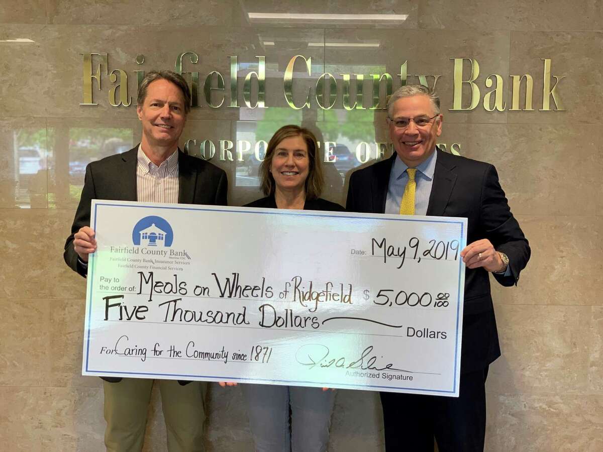 David Schneider, Chief Executive Officer of Fairfield County Bank, presents Dean Miller and Phyllis Appel, of Meals on Wheels of Ridgefield, with a $5,000 donation.