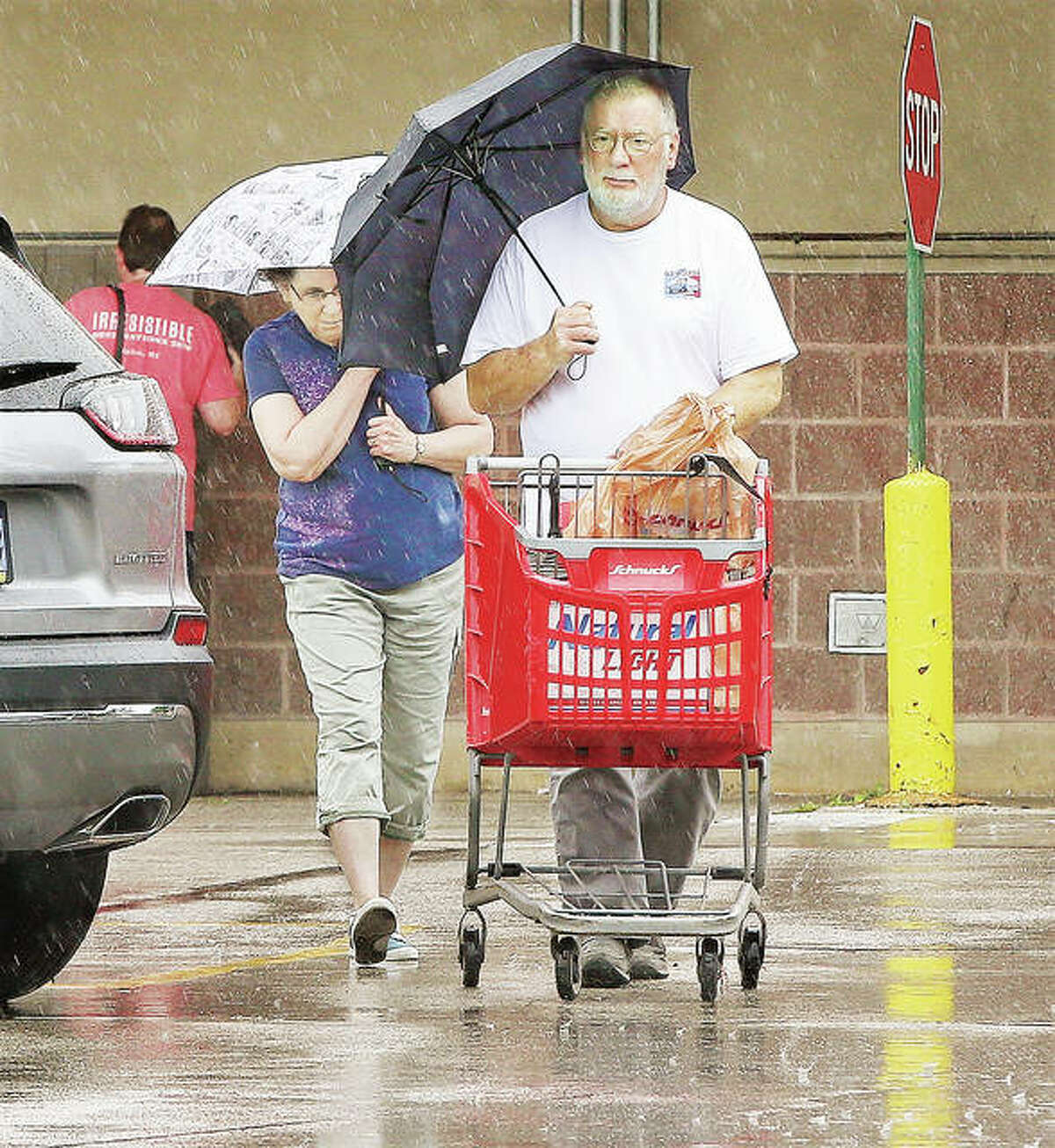 As the Carpenters once said in a song, “Rainy days and Mondays always get me down.” This couple had both as they made a dash to their vehicle with their groceries in the pouring rain at the Alton Schnucks store in the 1700 block of Homer Adams Parkway in Alton. After more rain today, forecasts call for temperatures to skyrocket to the upper 90,s and near 100 degrees through Sunday.