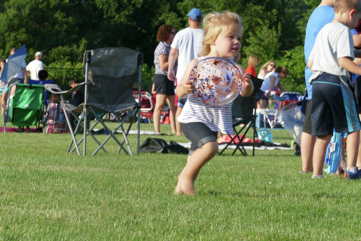 Kiera, 3, plays with a Frisbee during the annual Fourth of July celebration at Ridgefield High School last week.